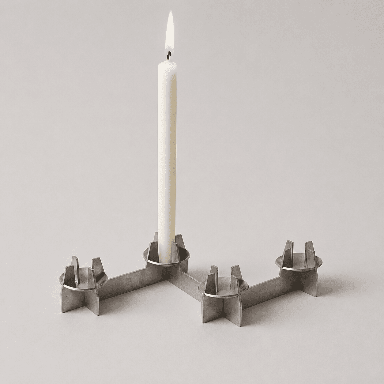 Portavelas de diseño minimalista en acero inoxidable.